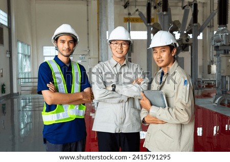 Three asian engineer standing in Factory or power plant background. Spirit of team work and success career.
