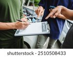 Three Asian men discussing car insurance policies with adjuster. They review details such as premiums, deductibles, coverage options while handling recent claim and evaluating the settlement process.