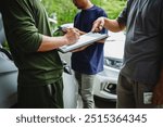 Three Asian men discussing car insurance policies with adjuster. They review details such as premiums, deductibles, coverage options while handling recent claim and evaluating the settlement process.