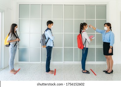 Three Asian Student Wearing Mask Standing Distance Of 6 Feet From Other People Keep Distance While Teacher Using Thermometer Temperature Screening Student For Fever While Student Coming Back To School