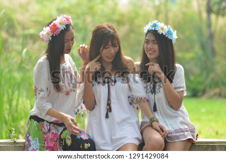 Three Asian teenage girls dressed in fashion style, Bohemians are doing a smiling way. Hugging, teasing a close friend