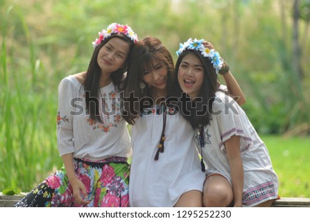 Three Asian teenage girls dressed in fashion style, Bohemians are doing a smiling way. Hugging, teasing a close friend