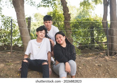 Three Asian Teenagers, 2 Men And 1 Woman Posing At The Park.