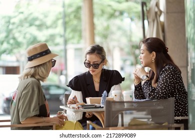 Three Asian Women Sitting Outside Coffee Shop Drinking And Chatting