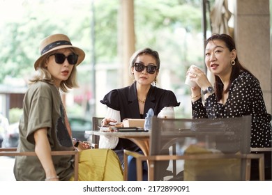 Three Asian Women Sitting Outside Coffee Shop Drinking And Chatting