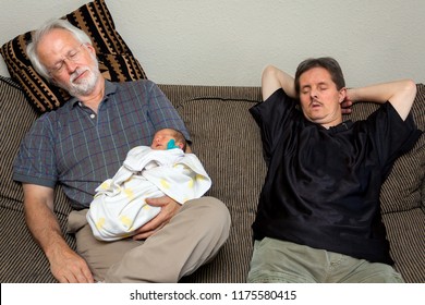 Three Asleep On A Couch.  A Grandfather Holds His Brand New Granddaughter And His Brother-in-law With Downs Syndrome Sits Next To Them On A Striped Couch. All Three Are Exhausted And Asleep.