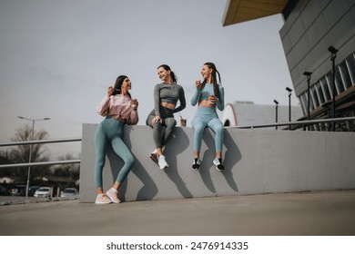 Three athletic friends enjoying a light moment together on a sunny day after a workout session, sharing stories and laughter. - Powered by Shutterstock