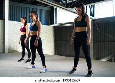 Three Attractive Women Preparing For A HIIT Class In The Fitness Center. Active Women In Sportswear Starting Their Cardio Workout Together