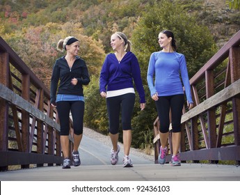 Three attractive young women talking a walking together