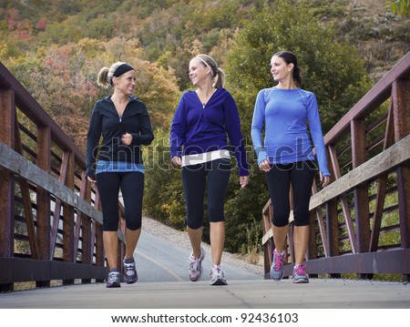Three attractive young women talking a walking together