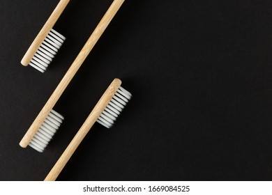 Three Bamboo Tothbrushes On Black Background With Copyspace, Room For Text
