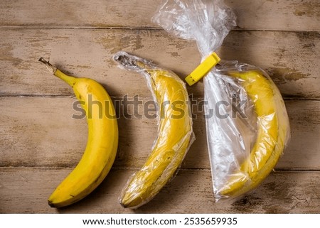 Three bananas, one without packaging, the second in food wrap, the third in a plastic bag, different storage, experiment