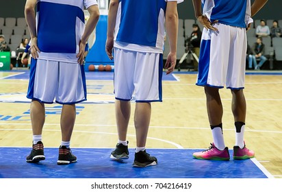 Three Basketball Players Stand On The Basketball Court
