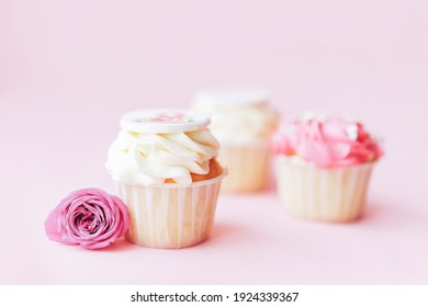 Three Beautiful Appetizing White And Pink Cupcakes Against A Pink Background. Sweet Dessert For Any Festive Table.