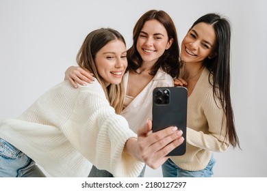 Three beautiful brunette women smiling and taking selfie photo isolated over white background - Powered by Shutterstock