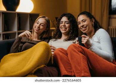 Three beautiful female friends have a movie night together - Powered by Shutterstock