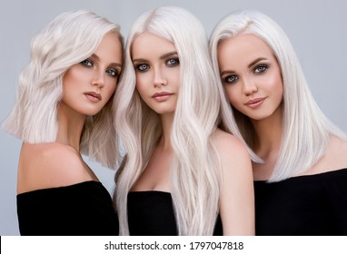 Three beautiful girls with hair coloring in ultra blond. Stylish hairstyle curls done in a beauty salon. Fashion, cosmetics and makeup
