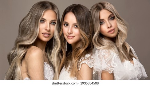 Drei schöne Mädchen in weißen Hochzeitskleider mit Haarfarbe in ultra blond. Stilvolle Frisuren in einem Schönheitssalon. Mode, Kosmetik und Make-up.Adorable Bräute