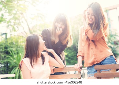 Three beautiful happy Asian girl smile and laugh together.Image with sunlight filter.