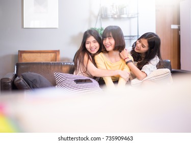 Three Beautiful Young Asian Woman Friends Hugging Smiling And Laughing Together At Home