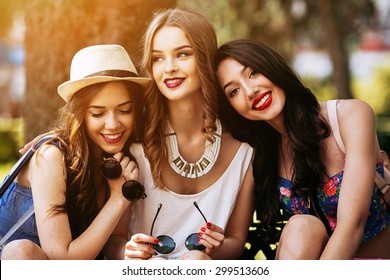 Three beautiful young girls posing against the backdrop of the park - Shutterstock ID 299513606