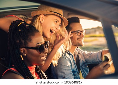 Three best friends enjoying traveling at vacation in the car. - Powered by Shutterstock