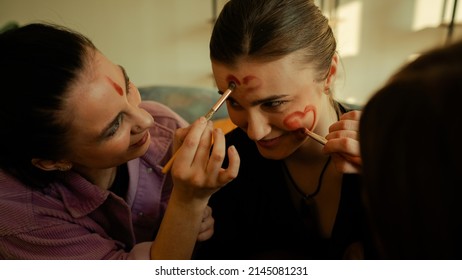 Three Best Friends Having Fun In A Pastel Toned Cozy Living Room While Doing Eachothers Make-Up And Feeling Joyiful. Brunette Girls Hanging Out.