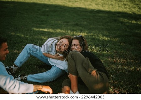 Happy women embracing and laughing over nature background