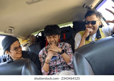 Three best male friends travel together. Sitting in a backseat car and having fun singing to a song. Summer adventure concept. - Powered by Shutterstock