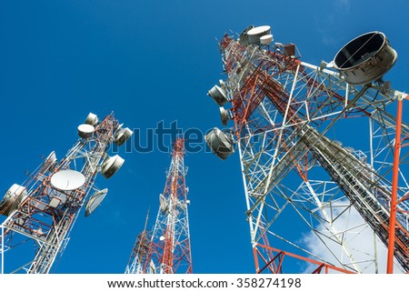three big radio mast with many dishes in blue sky and few cloud