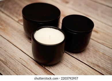 Three Black Candle Jars On Wood Floor