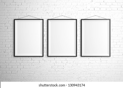 Three Black Frames On Brick Wall
