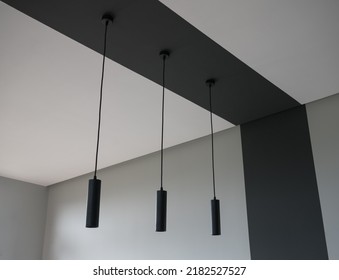 Three black modern bar lights hanged on black ceiling
