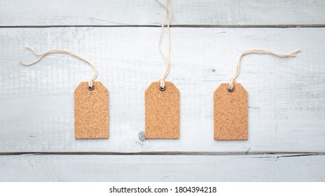 Three Blank Corkboard Tags Isolated On White Wood Texture Background