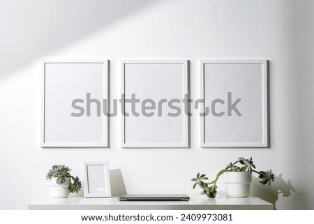 Three blank frames with copy space hanging on white wall