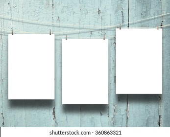 Three blank frames with pegs on weathered aqua wooden boards background - Shutterstock ID 360863321