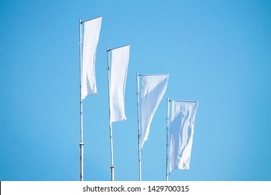 Three Blank White Flags On Flagpoles Against Cloudy Blue Sky With Perspective, Corporate Flag Mockup To Ad Logo, Text Or Symbol, Company Identity Flag Template With Copy Space