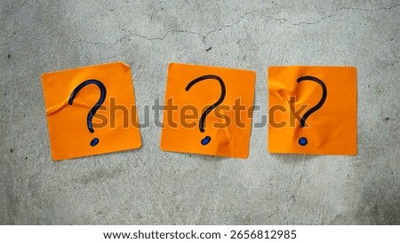 Three Blue Question Marks on Orange Sticky Notes on a Cracked Concrete Background