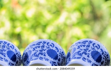 Drei blaue und weiße Keramikvasen auf schönem grünem Hintergrund