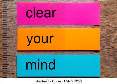 Three Bookmark Stickers With The Word Clear Your Mind On A Dark Natural Wooden Table