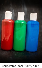 Three Bottles Of Acrylic Paint In The Order Red, Green, Blue, The Primary Colors Of The Additive RGB Color Space