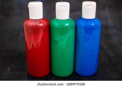 Three Bottles Of Acrylic Paint In The Order Red, Green, Blue, The Primary Colors Of The Additive RGB Color Space