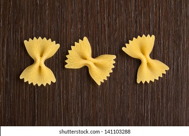 three bow tie pasta on wooden background - Powered by Shutterstock