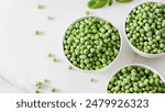 Three bowls of frozen green peas on a marble surface. Healthy vegetables