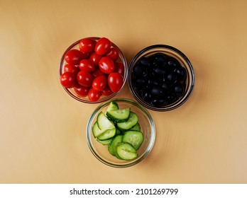 Three Bowls With Tomatoes, Black Olives And Chopped Fresh Cucumbers. Salad Ingredients.