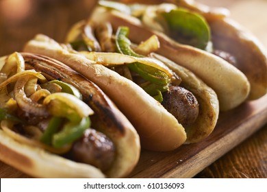 Three Bratwurst Sausages With Grilled Onions And Bell Peppers