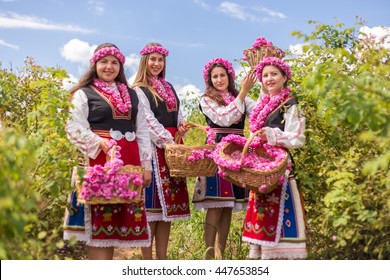 Three Bulgarian girls dressed in traditional dress picking roses during the Annual Rose Festival in Kazanlak, Bulgaria