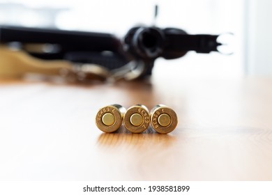 Three Bullets Bottom Against Blurred Kalashnikov Assault Rifle Background. Cartridges 7.62 Caliber For Ak 47 Closeup.