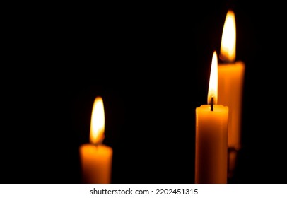 Three burning candles in the dark. Candle flame in darkness. Candles flames in dark. Three candles burning