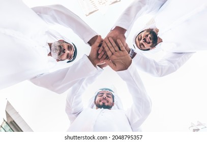 Three business men walking in Dubai wearing traditional emirati clothes